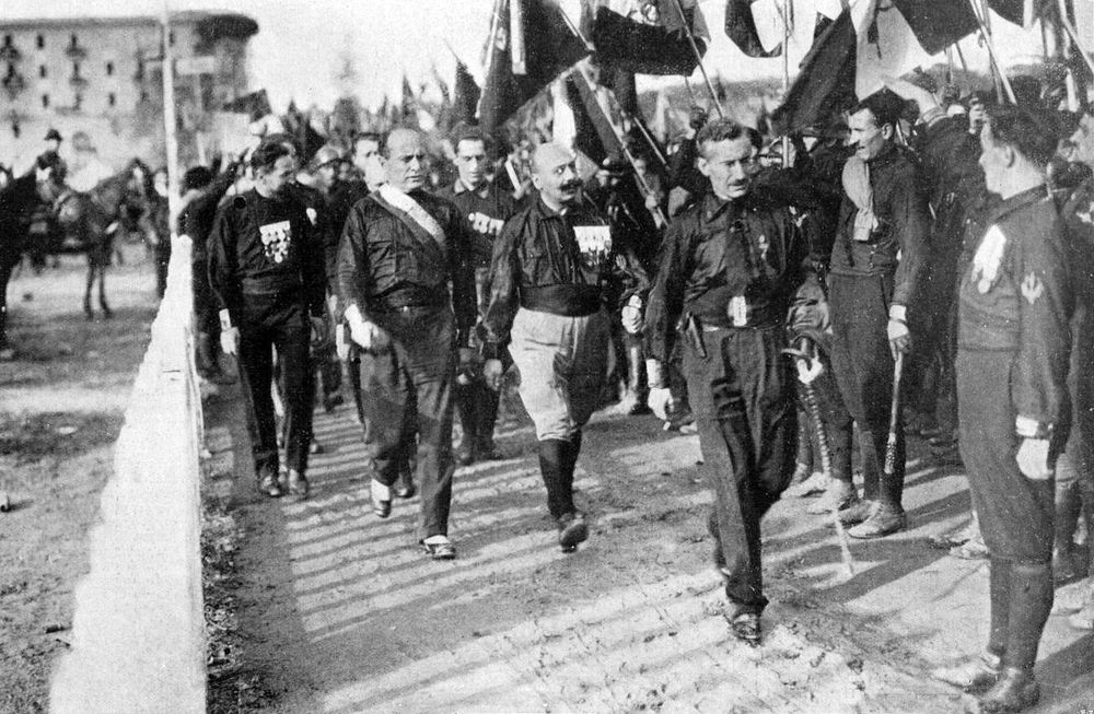 From left to right: Italo Balbo, Benito Mussolini, Cesare Maria de Vecchi and Michele Bianchi, during the fascist march on Rome, in October, 1922. By Unknown author - Illustrazione Italiana, 1922, n. 45, Public Domain, https://commons.wikimedia.org/w/index.php?curid=48015630