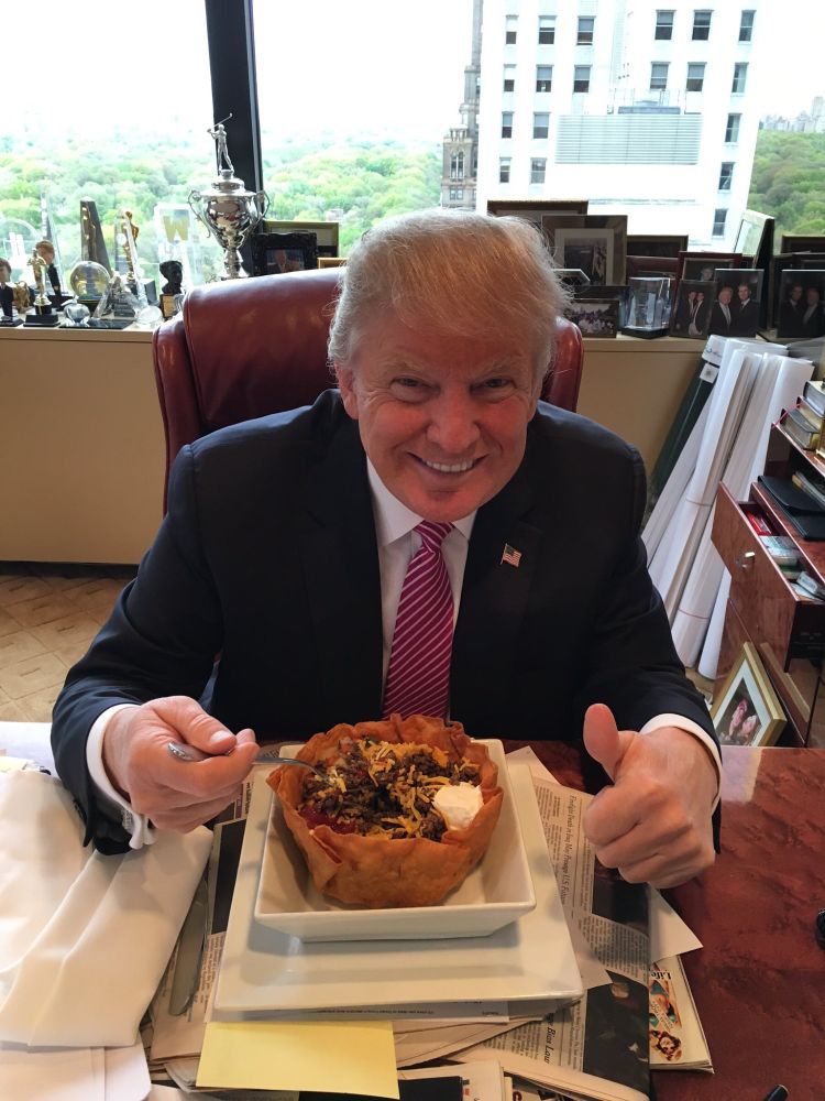 Orange man eating taco salad bowl.