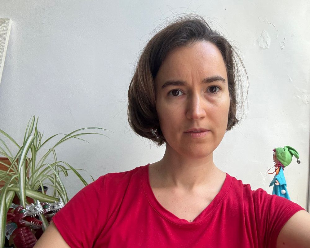 me in chair, plant now closer to my right shoulder. two-headed dragon creeping up through leaves; tiny puppet has moved to the other side of me, just to be safe.