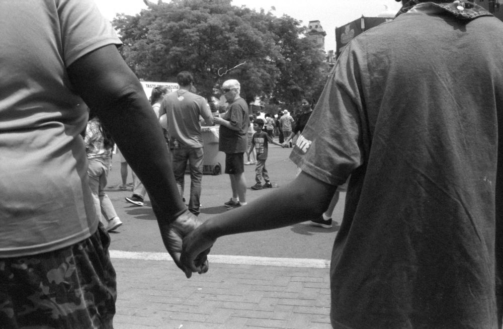 Black and white Photograph of a couple holding hands with their backs to the camera 