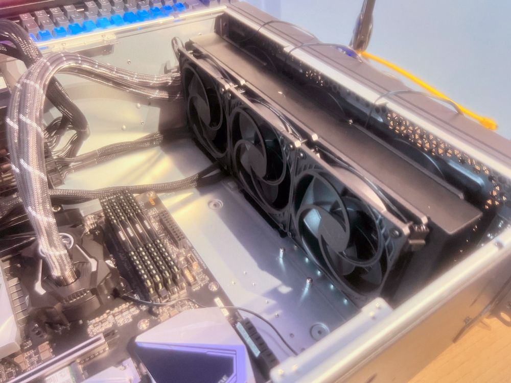 Close-up of the interior of a desktop computer build, showcasing the motherboard, RAM sticks, neatly managed cables, and Arctic Freezer II 360 cooling system with 6 Arctic P12 fans in push-pull configuration.