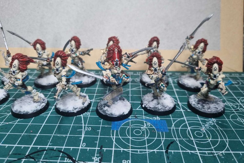 a close-up on then ten model unit of howling banshees. they are sitting on my crafting desk. the howling banshees are in bone and reds. i painted these all myself.