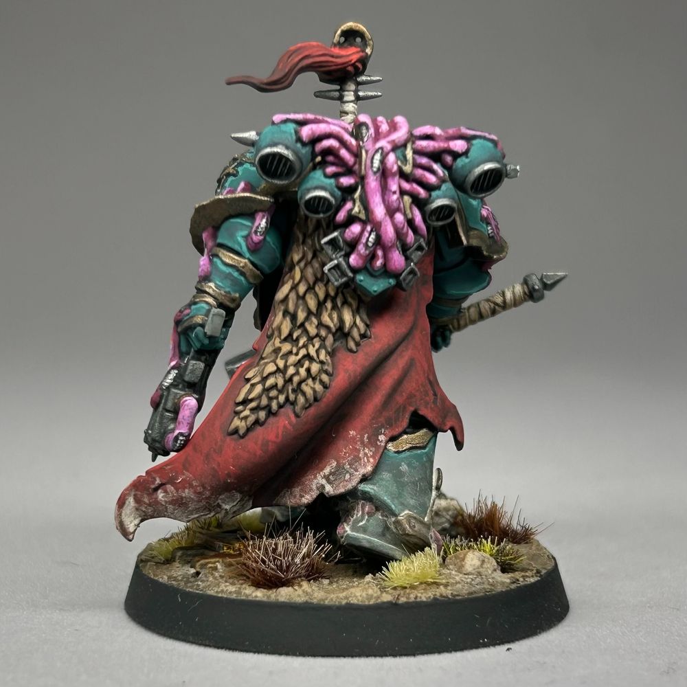 Chaos Space Marine striding forwards through arid grasslands and looking not too happy. Because he's Chaos... probably. They tend not to be. I blame the diet. Anyway, he's marching along with a big old hammer with glowy runes on it and is looking for trouble.