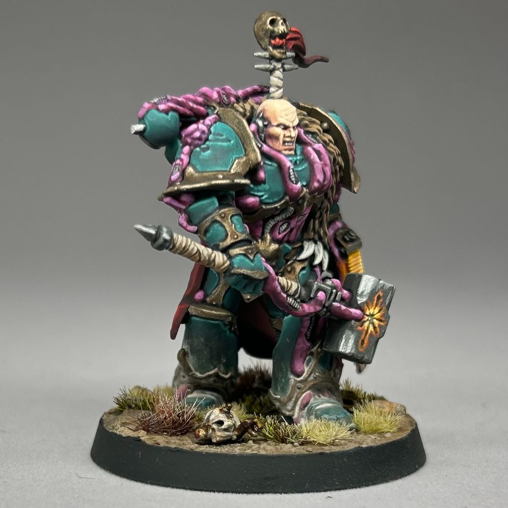Chaos Space Marine striding forwards through arid grasslands and looking not too happy. Because he's Chaos... probably. They tend not to be. I blame the diet. Anyway, he's marching along with a big old hammer with glowy runes on it and is looking for trouble.