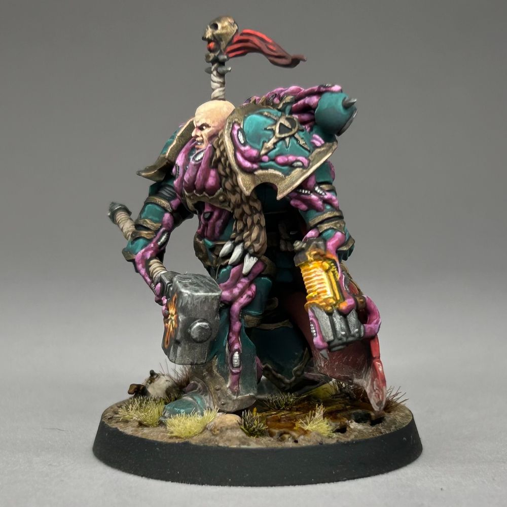 Chaos Space Marine striding forwards through arid grasslands and looking not too happy. Because he's Chaos... probably. They tend not to be. I blame the diet. Anyway, he's marching along with a big old hammer with glowy runes on it and is looking for trouble.