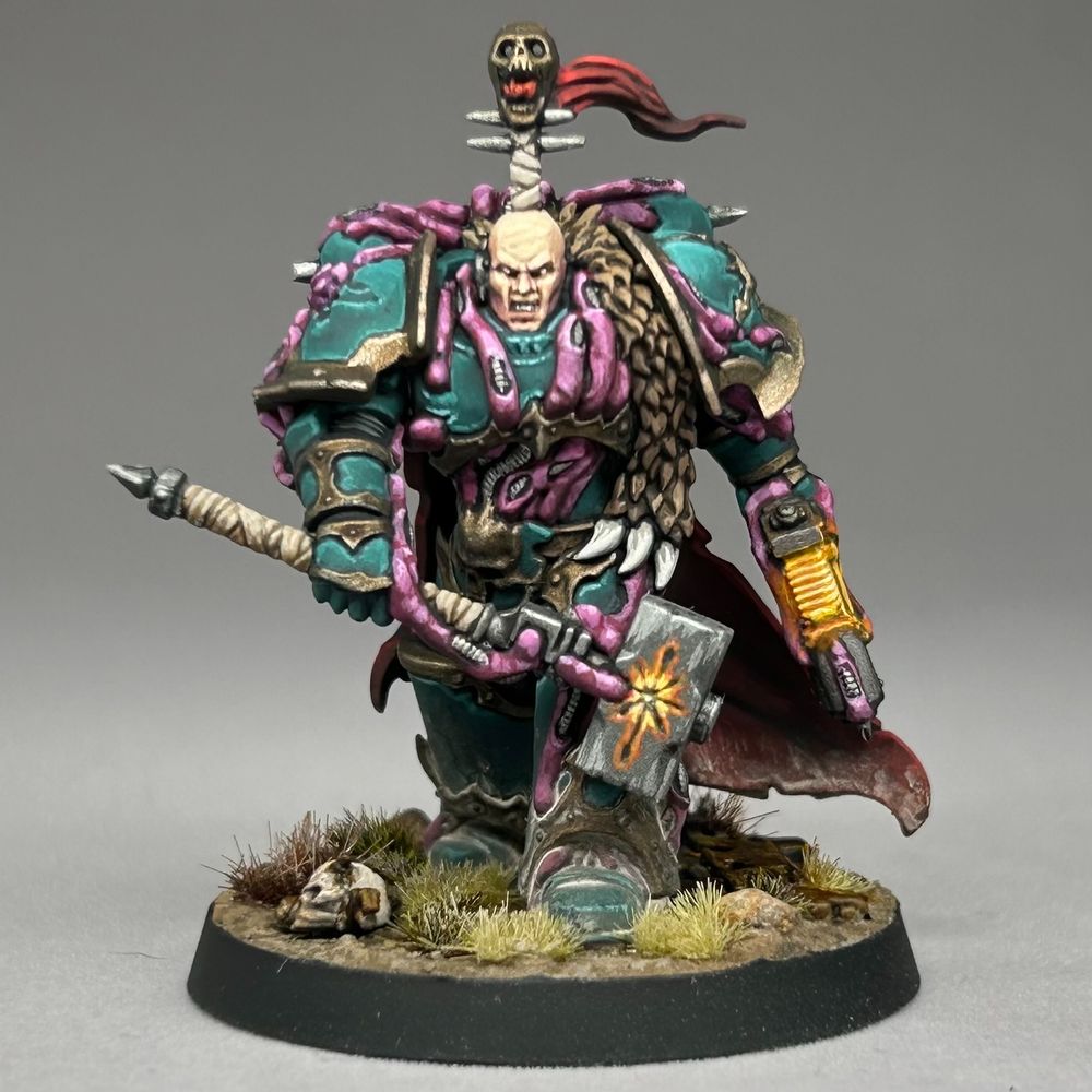 Chaos Space Marine striding forwards through arid grasslands and looking not too happy. Because he's Chaos... probably. They tend not to be. I blame the diet. Anyway, he's marching along with a big old hammer with glowy runes on it and is looking for trouble.