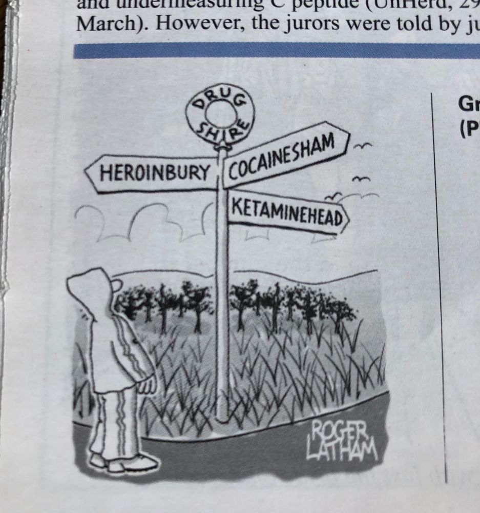 Someone at a pre-Warboys finger-post sign for 'Drugshire' pointing to Heroinbury, Ketaminehead and Cocainesham.