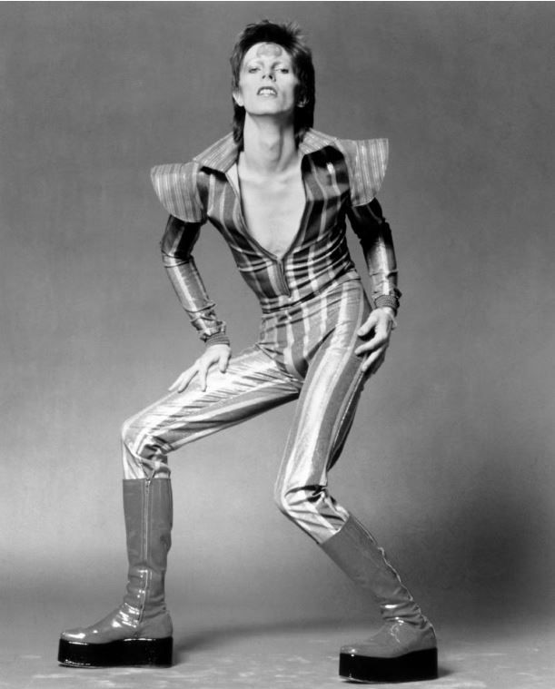 B&W photo of David Bowie in Ziggy Stardust phase, in cool vinyl boots.