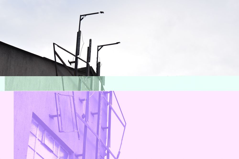 Building with metal bars sticking out on the side. File corruption has turned it purple and green.