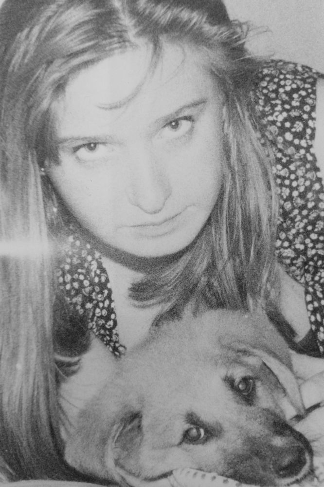 B&W photo of a woman - me - wotb a puppy.