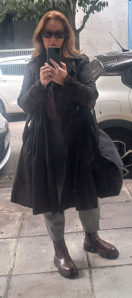 A woman dressed in boots and a light coat