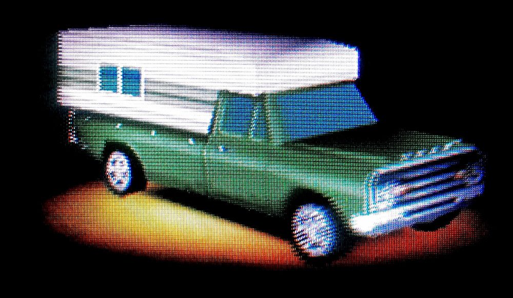 The '70 Stag Pickup. A green pickup with a slide-in camper attachment.