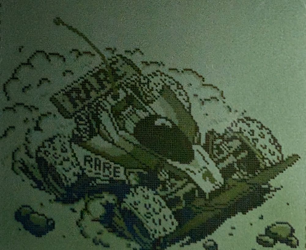 A remote control car racing in the dirt with the Rare logo on its spoiler 