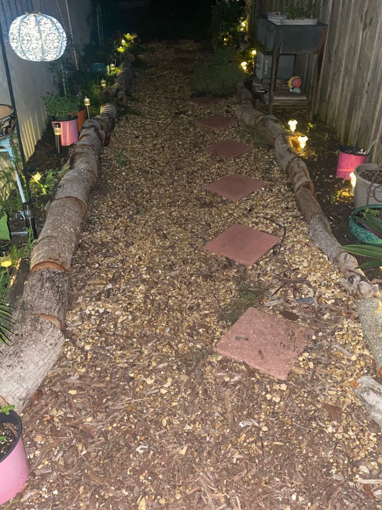 Pathway with brown pebbles and red square stepping stones. Lots of ground lights and a few gnomes in there making mischief 