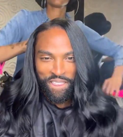 A man with an immaculate silk press staring into the camera with all of the confidence someone can muster.