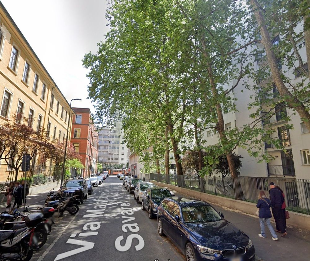 Google Streetview of a street lined with cars and motorbikes parked on either side