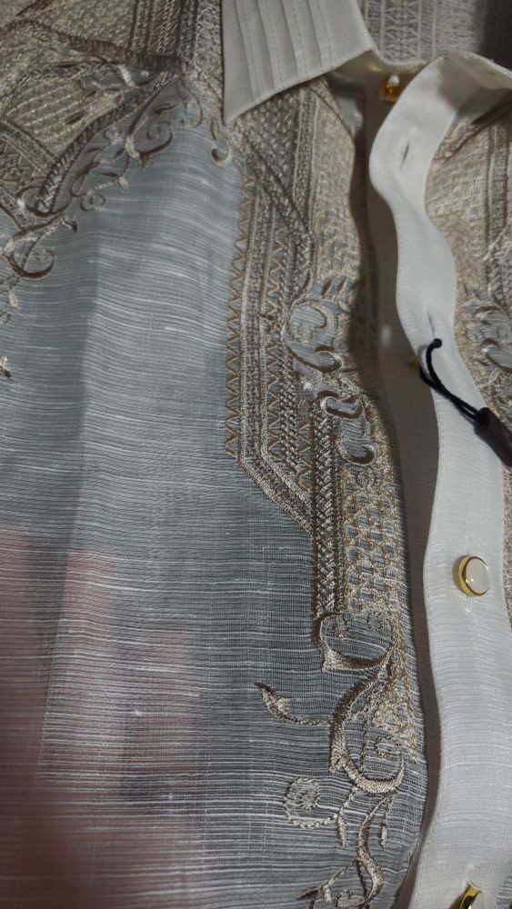 Detail on the barong filipino. The embroidery has strong square shapes and soft leaf shapes 