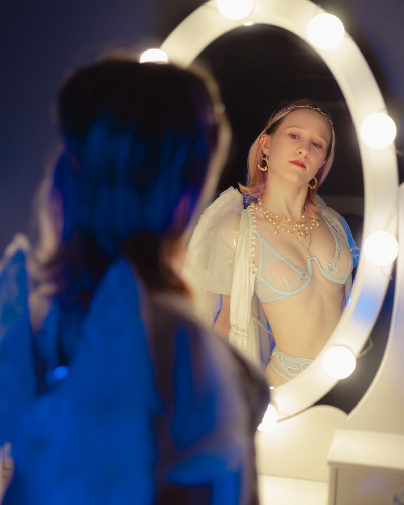 Same location and outfit but my head is tilted upwards more and looking into the mirror seriously with a hint of curiosity. 