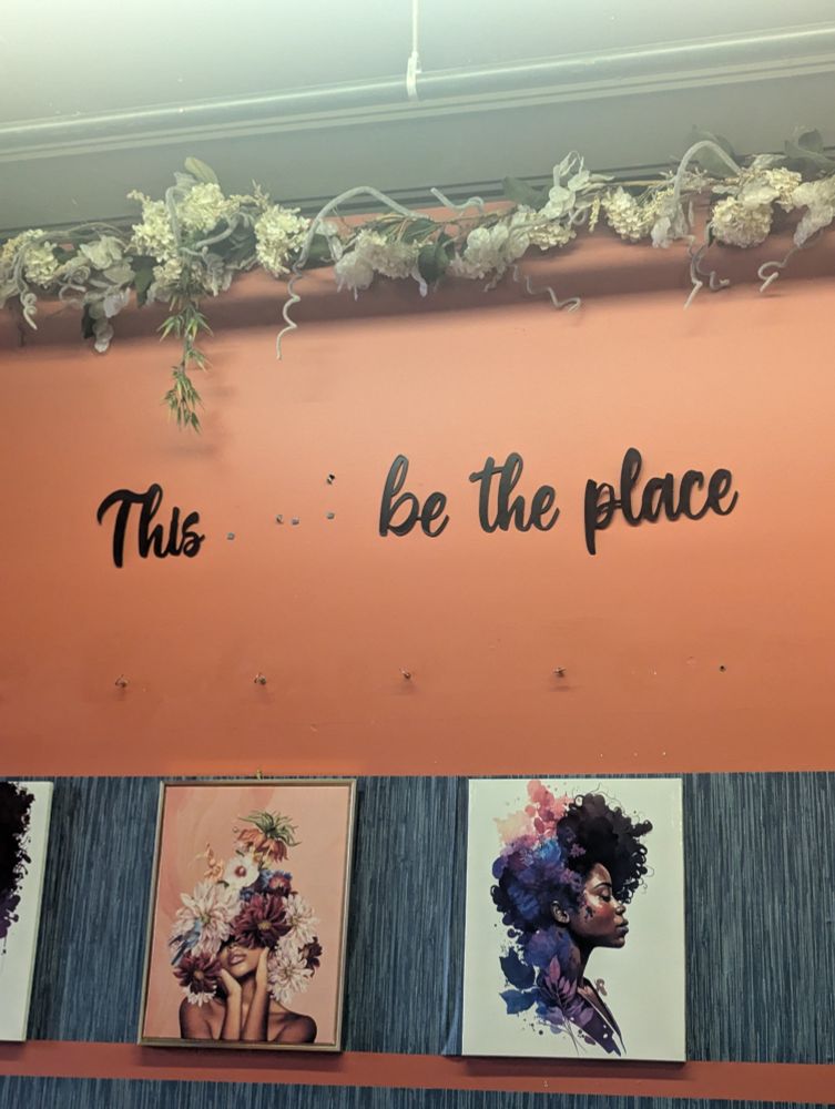 a wall print that says "this be the place" with a huge gap between "this" and "be", presumably where the word "must" once sat   