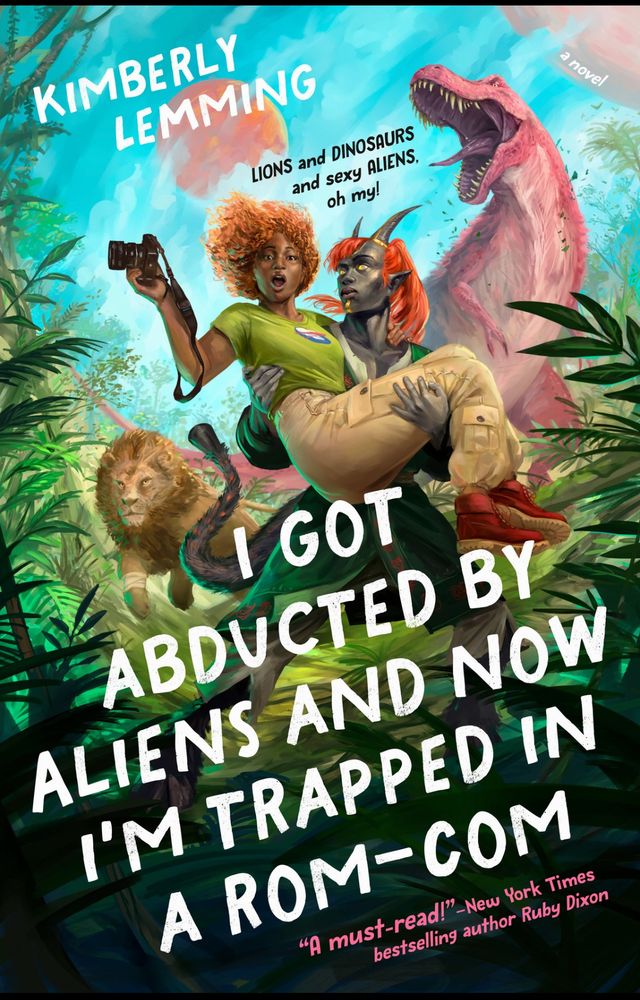 Book cover for I Got Abducted by Aliens and now I’m trapped in a rom-com. By Kimberly Lemming. Black woman with red hair being carried by a Black Alien with horns. And red hair. A pink Dinosaur and a lion in the background 