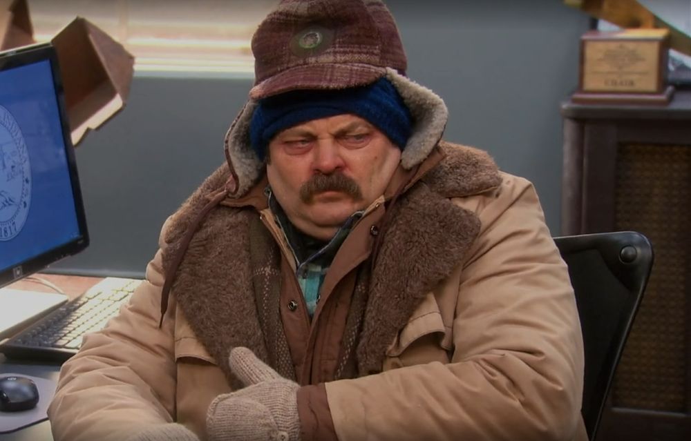 ron swanson from parks and rec wrapped in layers looking very ill