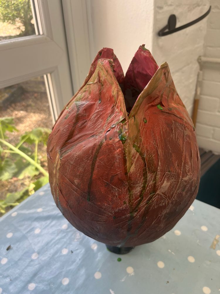 A nasty paper mache egg in the style of alien, its is pinky brown and drips green slime 
