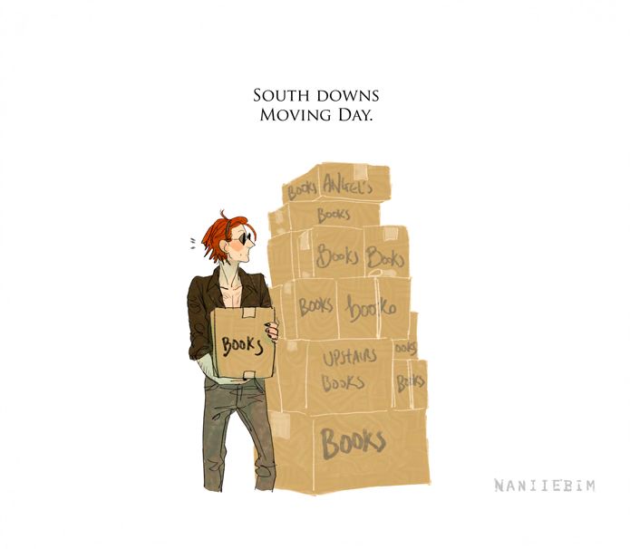 South downs moving day- tv crowley with mid length hair in a headband, skinny jeans and rolled up shirtsleeves carrying a box of books and looking thoughtfully at a taller than crowley pile of book boxes next to him