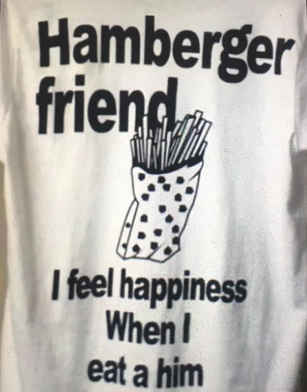 blurry cropped photo of a tshirt with the words "Hamberger friend" "I feel happiness When I eat a him" with a drawing of a bag of french fries 