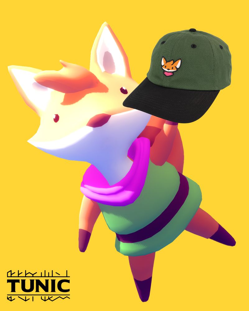 TUNIC fox holding a new official hat from Fangamer that features an illustration of the fox with extra large ears. 