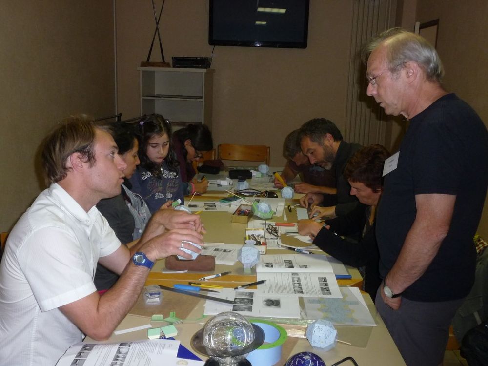 Des stagiaires concentrés sur la construction de leur maquette lors de l'école d'été d'astronomie du Clea.