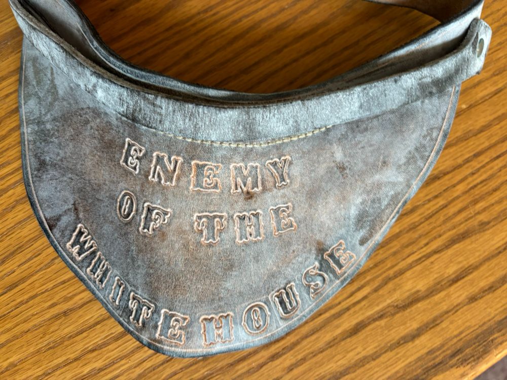 An aged leather visor bill, which is stamped in call capital letters "Enemy of the White House." From the Jerry and Mildred Wurf papers, Reuther Library, Wayne State University.