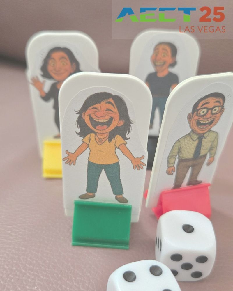 Four, DIY, custom game pieces featuring illustrated characters mounted on colored stands (green, yellow, and red) are arranged on a surface. Two white dice with black dots are placed in front of the pieces. In the upper-right corner, the text “AECT 25 LAS VEGAS” appears in colorful letters.