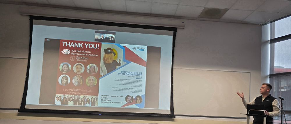 A speaker presents at Stanford, with a slide showing thanks to the Wu Tsai Human Performance Alliance and promoting a workshop on integrating XR with biosensors using LABO.
