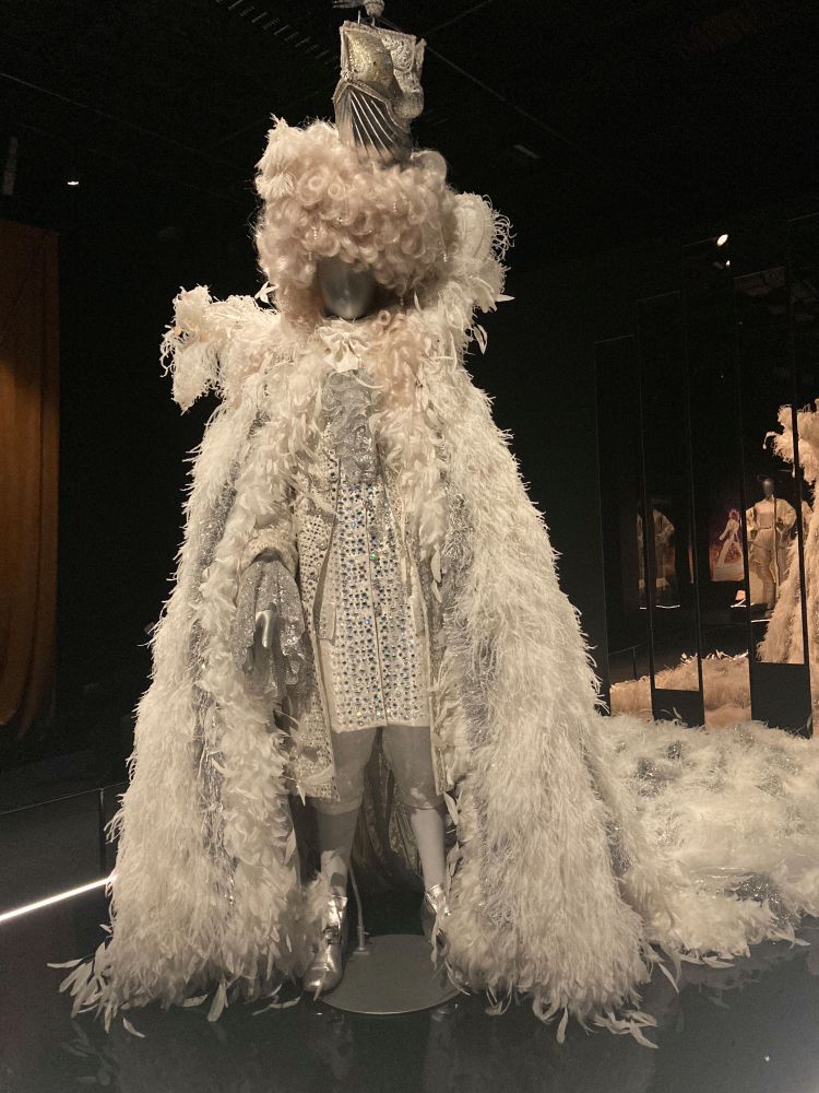 A feathered cloak, heavily beaded tunic, silver boots, white curly wig with a metal sailing ship on the top.