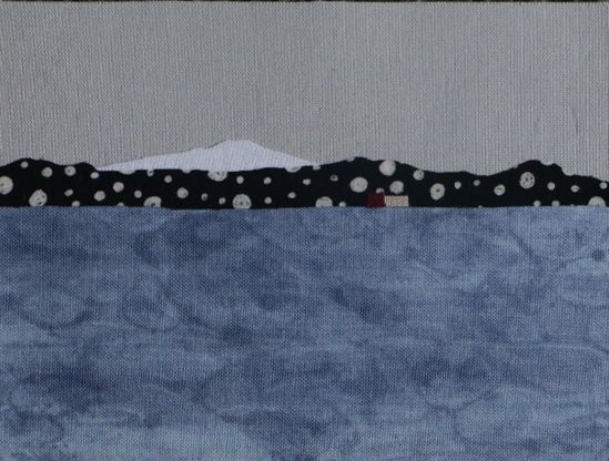 Postcard sized fabric landscape with the buildings at McMurodo Station, with Mt Erebus in the background. A grey sea is in the foreground.