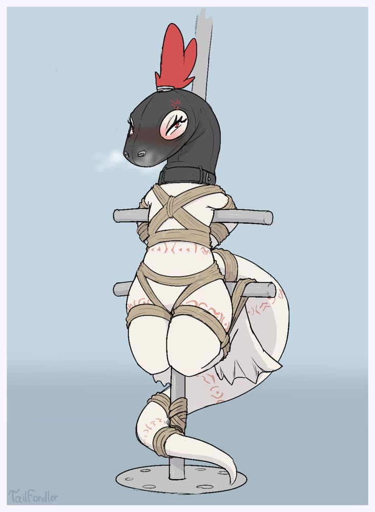 White lizard lady hung up on a metal pole. The pole is made of one vertical metal bar and two shorter ones perpendicular to it. The lizard is tied to the bars with lots of rope and hung up by the horizontal metal bars. Her arms are tied behind her back and her legs are frog-tied. Her head and neck are covered in a rubber / leather hood with just holes for the eyes and nostrils~