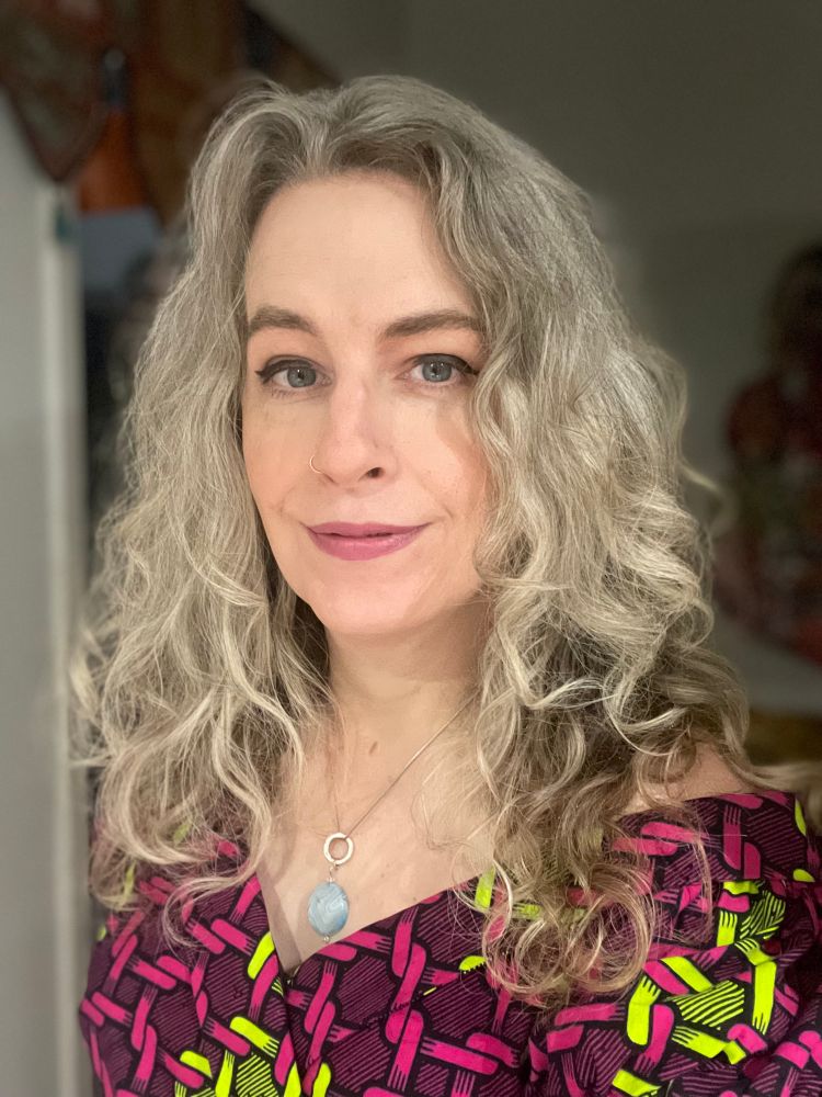 Erin lookin’ like a snack with her curly hair and multicoloured dress