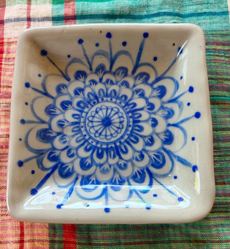 A beautiful porcelain square shallow bowl with a blue abstracted flower design painted with blue glaze.