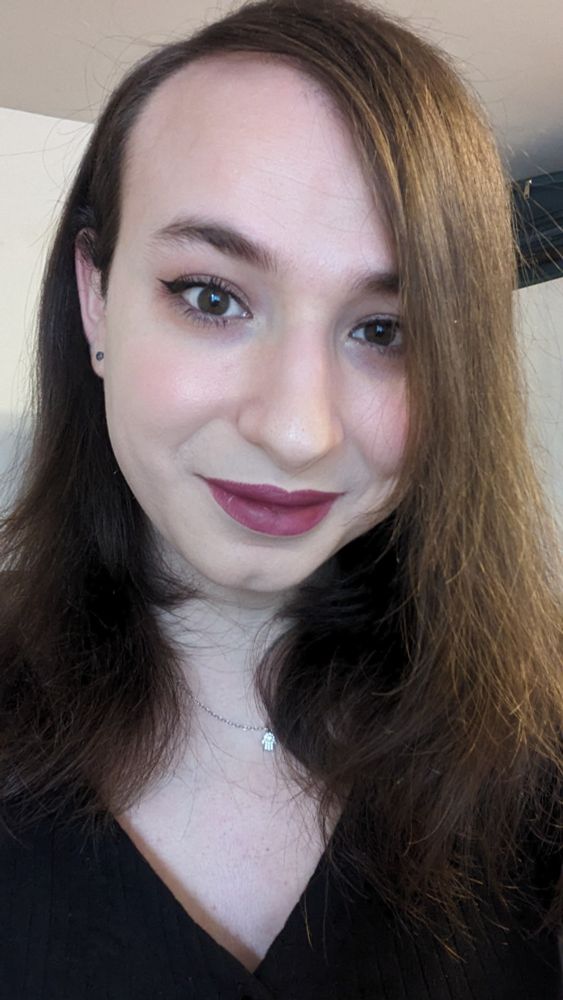 It's Danielle! Her hair is in a deep side part, and she's wearing a V-neck t-shirt. 