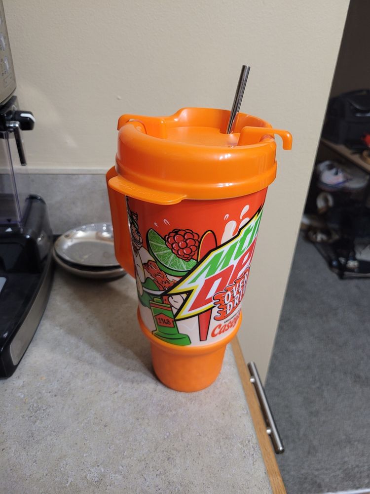 Large orange plastic refillable cup with branding on it for Mountain Dew Overdrive and Casey's gas stations.

The cup has a large handle and a lid with a piece that swivels to open and close.
