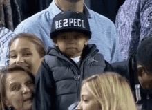 Small child tipping hat with RESPECT written on it