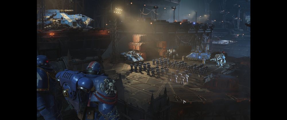 Screengrab from Space Marine 2 serving up some heavy vibes for fans of the tabletop game. Player looking out over a battle group of Ultramarines.
