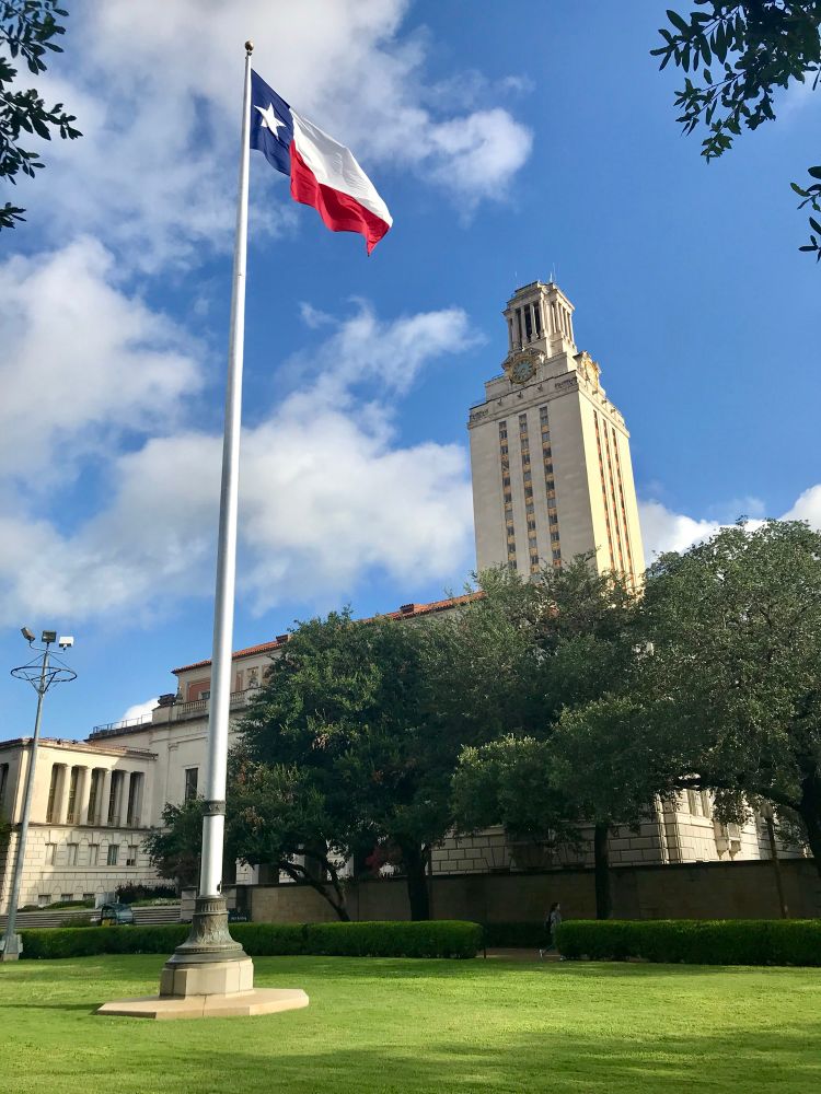 UT tower with Texas flag in the foreground 