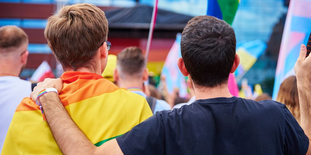 'What the Research Says About Supporting LGBTQ+ Youth' post feature photo showing two young people at a pride parade