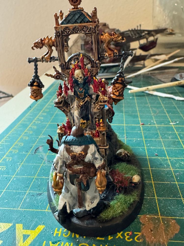 A scalding covered in red candle, wax being carried on the same by the same who strong men wearing old robes while having her hand nail tube thing with an all glass on its lap.