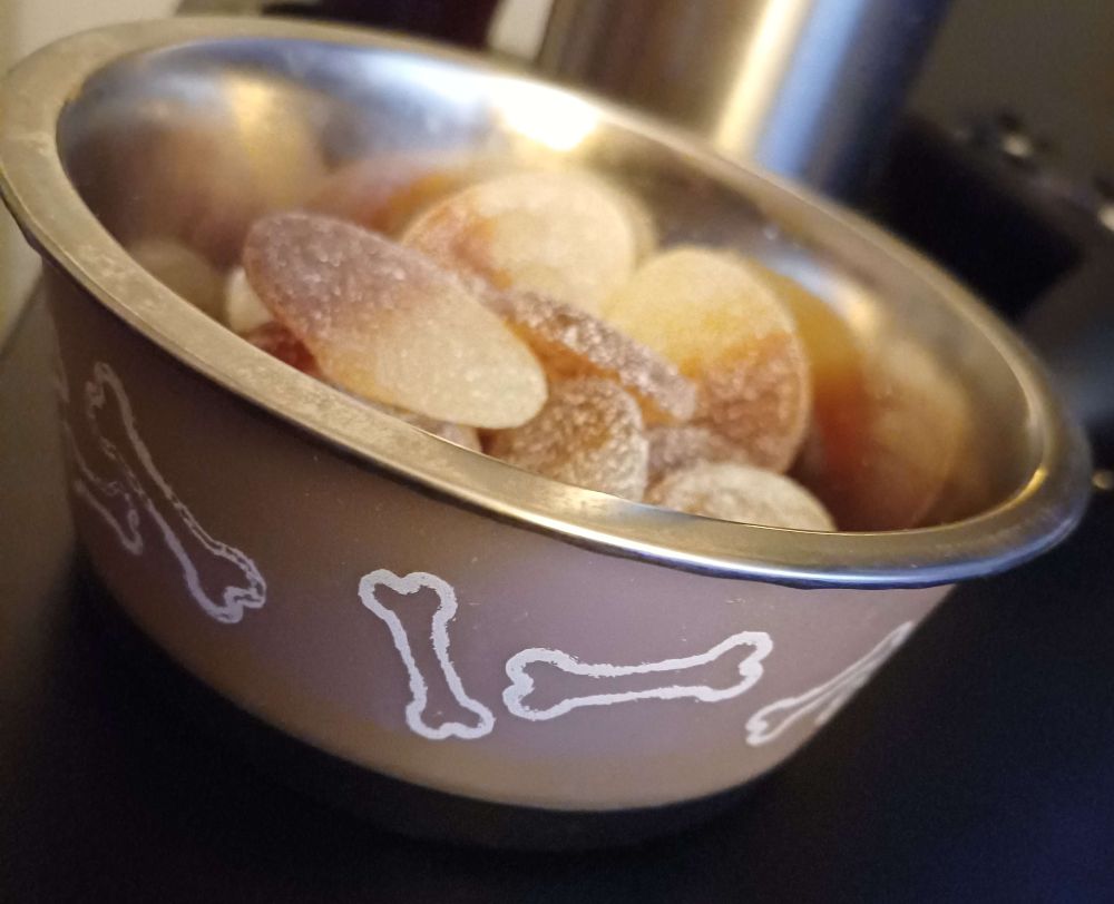 Sour candy in a dog bowl with bone treat motifs all around.
