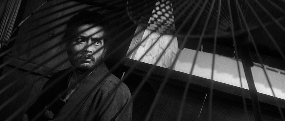a bearded Tatsuya Nakadai in Harakiri on the left side of the frame, seen through the ribs of a parasol 