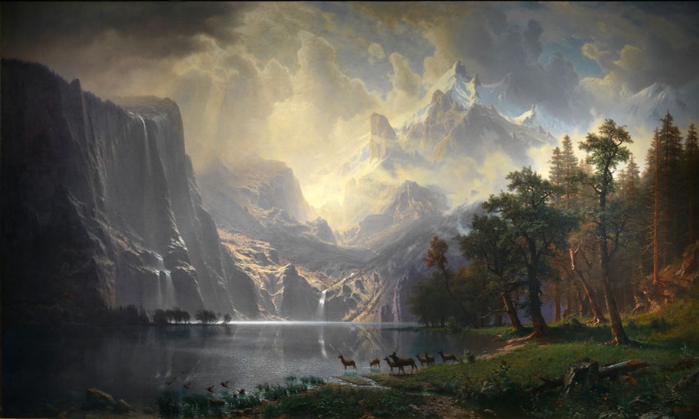 Albert Bierstadt’s Among the Sierra Nevada Mountains, oil on canvas, 1868
View of the Sierra Nevada Mountains. In the bottom right corner of the painting, there’s a patch of deep green grass and forest, seven deer (including one stag) and birds that look like geese or ducks flying into the water. The mountains occupy the entire background and most of the left side of the painting, some of the peaks in the far back are snow capped. Two waterfalls pour into water that's almost a gunmetal color with a blue tint, the water is mostly still except for a layer of silver mist in the far background and ripples where the birds and deer are. The waterfall and face of the mountain are reflected in the water's surface. The colors on the right side of the painting are warm and rich, but they become darker and cooler toward the left side, where the face of the mountain almost looks made of steely gray stone. Like the other painting, the sun is obscured but its rays are diffused through thick clouds that shift from a pale yellow to stormy gray.
