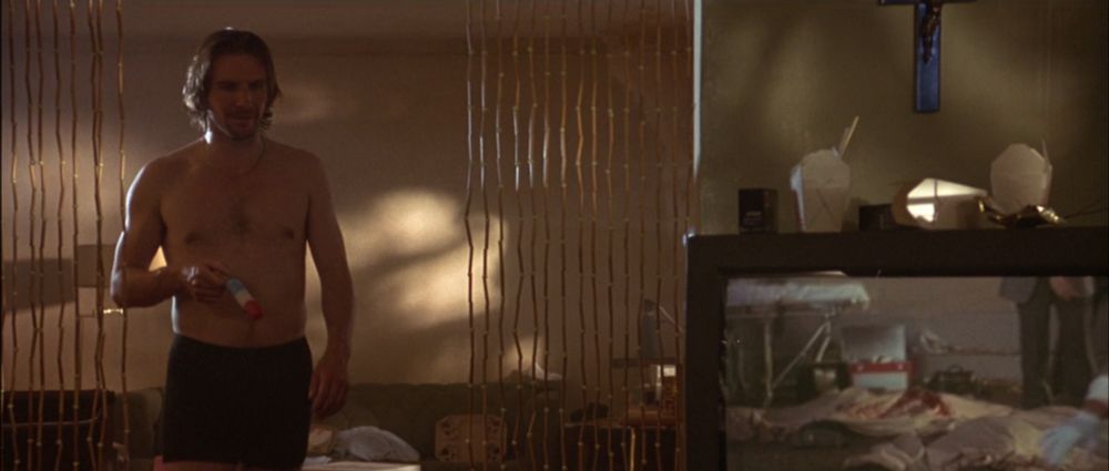 slight variation on 2nd screenshot, with shirtless Fiennes in black boxer-briefs holding his popsicle on the left side of the frame, the TV on the right side of the frame