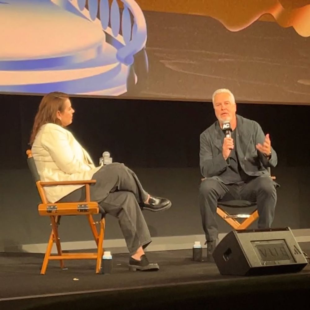 handsome William Petersen wearing charcoal gray/black fit on stage speaking with Katie Walsh in a Miami Vice-esque linen blazer 